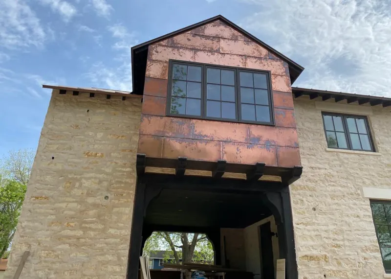 Copper metal panel facade on a stone building for Roof Repair in Wall